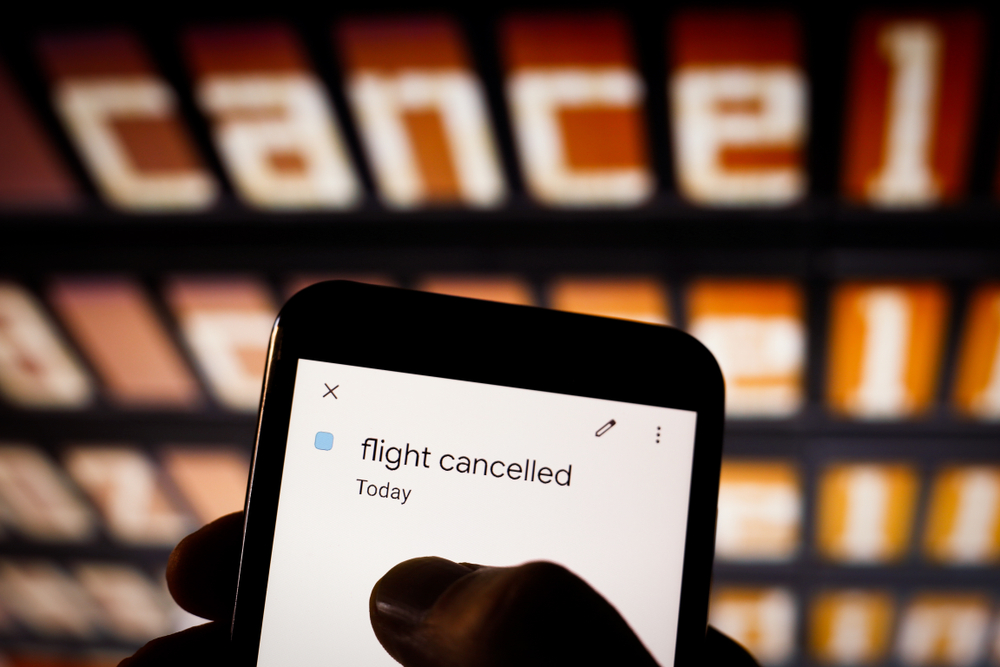 View,On,Smartphone,Screen,At,Airport.,Typing,Finger.,Flight,Cancelled